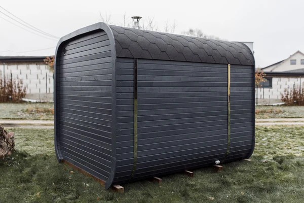 Modern Curved Sauna Pod with Integrated Porch, Weatherproof Dark Grey Exterior &amp; Wood Heater for Year-Round Outdoor Relaxation Door and glass